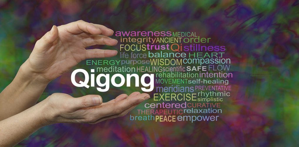 Qigong Healing word cloud - female cupped hands with the word QIGONG between surrounded by a word cloud on a rich dark multicolored background